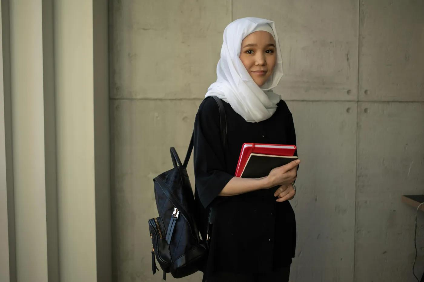 Asian woman in hijab with notebooks
