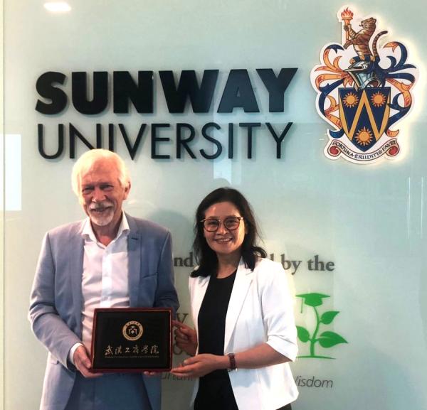 President Professor Sibrandes Poppema graciously receiving a souvenir from Professor Peng Xiuchun, Chairman of Wuhan Technology and Business University (WTBU)